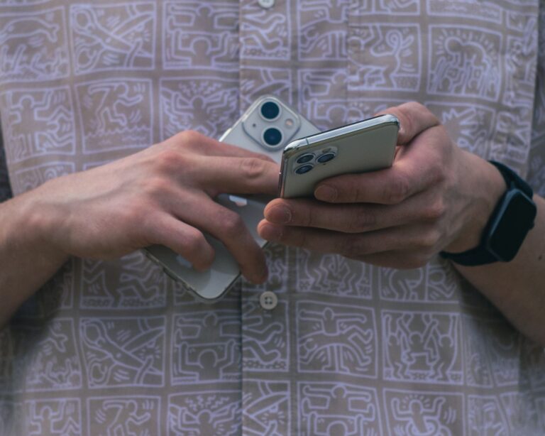 Traveller holding two smartphones side by side while moving accounts to a new phone number abroad
